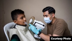 Uno de los especialistas médicos a bordo del Comfort toma radiografías dentales a un niño en Puerto Cortés, Honduras. (Foto: U.S. Naval Forces Southern Command & U.S. 4th Fleet)