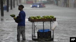 Un vendedor de aguacates en una inundación en La Habana, el 29 de agosto de 2023. El cambio climático podría tener un impacto muy negativo en las economías regionales, alerta la CEPAL.