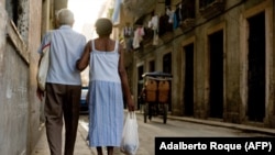 Ancianos caminan tomados del brazo por una calle de La Habana. (Adalberto Roque/AFP/Archivo)