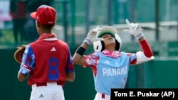 Aimar Lima (1) celebra parado en primera base después de conectar un hit en el juego de este domingo contra Cuba. (AP Photo/Tom E. Puskar)