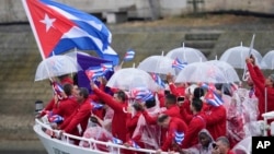 El barco que transporta al equipo cubano avanza por el Sena en París, Francia, durante la ceremonia de apertura de los Juegos Olímpicos de Verano de 2024, el viernes 26 de julio de 2024. (Foto AP/Lindsey Wasson)