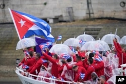 El barco que transporta al equipo cubano avanza por el Sena en París, Francia, durante la ceremonia de apertura de los Juegos Olímpicos de Verano de 2024, el viernes 26 de julio de 2024. (Foto AP/Lindsey Wasson)