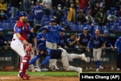 El italiano John Valent se lanza a la base durante el juego contra Cuba en el Clásico Mundial de Béisbol, en el Estadio Intercontinental de Taichung, Taiwán. (Foto AP/I-Hwa Cheng)