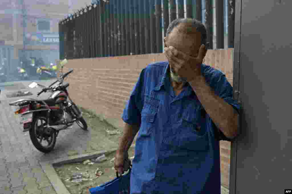 Un hombre se cubre la cara de gases lacrimógenos durante Nicolás Maduro en Caracas 29/072024 (Foto de YURI CORTEZ / AFP)