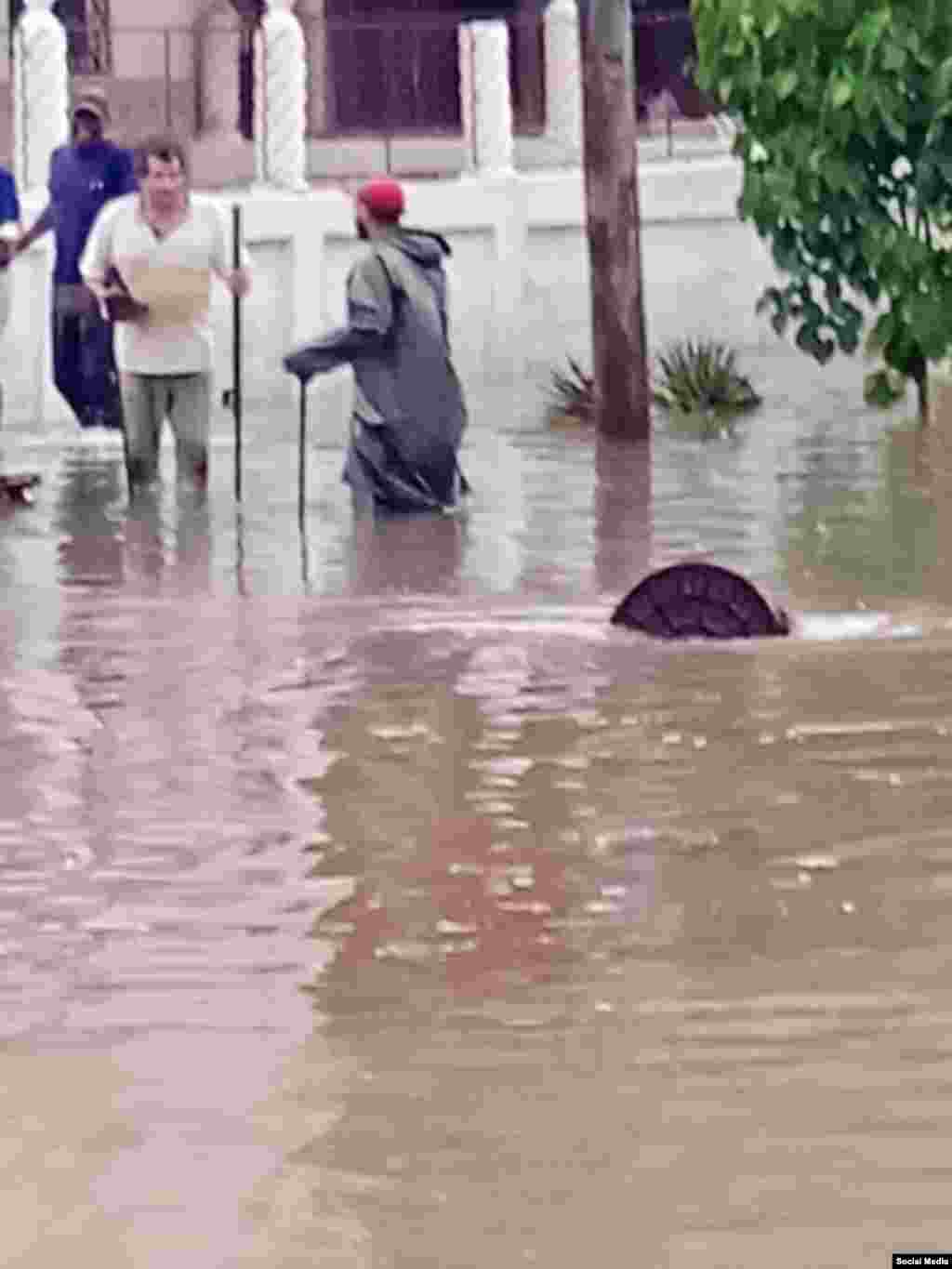 Las alcantarillas tupidas contribuyen a la acumulación de las aguas en las calles afectadas por las inundaciones, en el Vedado, La Habana. Calles inundadas en El Vedado. (Facebook/Comunicación Dgtph)