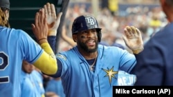 Yandy Díaz, de los Rays de Tampa, es felicitado por sus compañeros tras su cuadrangular de dos carreras ante los Bravos de Atlanta, el 9 de julio. (AP/Mike Carlson)