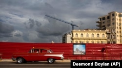 Automóvil clásico pasa por una calle donde se proyecta construir un hotel en La Habana. (Archivo AP/Desmond Boylan)