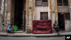 Mujeres sentadas en la acera de una calle, en La Habana, Cuba, el 9 de julio de 2022. (Foto AP/Ramon Espinosa)