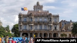 Una turba de agentes de civil y soldados avanza frente a la embajada de España en Cuba para reprimir a manifestantes el 11J.