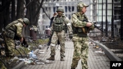 Soldados rusos caminan por una calle en Mariúpol el 12 de abril de 2022, mientras las tropas rusas intensifican una campaña para tomar la ciudad portuaria. Esta foto fue tomada durante un viaje organizado por el ejército ruso. Foto: AFP, Alexander Nemenov.