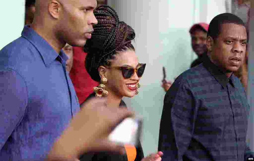 La cantante estadounidense Beyoncé (c) y su esposo, el rapero Jay-Z (i) salen hoy, jueves 4 de abril de 2013, del Hotel Saratoga en La Habana (Cuba), donde se hospedan junto a varios miembros de su familia, para celebrar los cinco años de su matrimonio. E