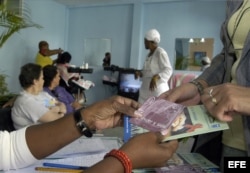 Una mujer recibe un plegable, un condón y el folleto "Mujer y SIDA" en una peluquería de La Habana.