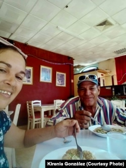 Kirenia González ( izquierda) y su padre Carlos Romel Teraz (derecha) comiendo.