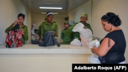 Oficiales del MININT revisan las provisiones que los familiares llevan a los reos en el Combinado del Este. (Adalberto Roque/AFP/Archivo)