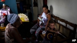 Fe María Llouvert abanica a su hija durante un apagón en La Habana, Cuba.