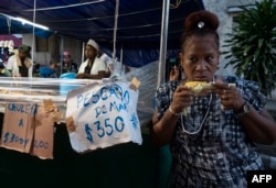 Los precios de un puesto de comida en Santiago de Cuba, el 26 de julio de 2023. Photo by Yamil LAGE / AFP