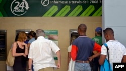 Un grupo de personas hace fila frente a los cajeros automáticos de un banco de La Habana (Foto: Yamil Lage/AFP).