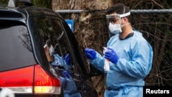 Un trabajador de la salud toma muestras de una persona para un examen de coronavirus, en Riverside Medical Goup, en Secaucus, Nueva Jersey, el 18 de marzo del 2020.