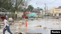 Una mujer camina por una calle llena de escombros en el barrio de Hastings, después del paso del huracán Beryl en Bridgetown, Barbados, el 1 de julio de 2024. REUTERS/Nigel R Browne