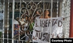 Jorge Cervantes muestra un cartel antigubernamental en su casa de Contramaestre.