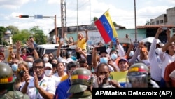 Partidarios del gobernador electo del estado de Barinas, Sergio Garrido, se reúnen frente a la sede del consejo electoral regional, rodeados por la Guardia Nacional, donde Garrido recibe su certificado ganador en Barinas, Venezuela, 10 de enero de 2022. Foto: AP/Matias Delacroix.