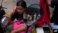 Una mujer sentada afuera del centro de detención de la Policía Nacional de Boleita, después de que su novio fuera arrestado durante las recientes protestas de la oposición contra los resultados oficiales de las elecciones presidenciales en Caracas. (Foto AP/Matías Delacroix)