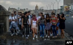 Un grupo de jóvenes camina por el Malecón de La Habana.