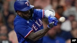 Adolis García, de los Texas Rangers, conecta un sencillo productor durante la primera entrada del Juego 7 de la Serie de Campeonato de la Liga Americana contra los Astros de Houston el lunes 23 de octubre de 2023 en Houston. (Foto AP/David J. Phillip)