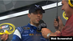 El piloto cubano Aric Almirola (c), es entrevistado tras su triunfo en la pista Daytona International Speedway.