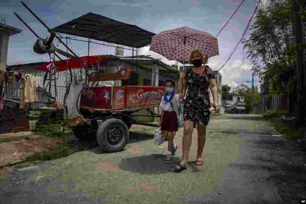 Danmara Triana camina de regreso a casa tras recoger a su hija Alice en la escuela, en Cienfuegos. (AP Foto/Ramón Espinosa)