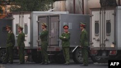 Policías custodian transporte para prisioneros en la Corte de Hanoi. 