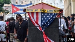 Un bicitaxi con la bandera estadounidense transporta turistas en La Habana. 