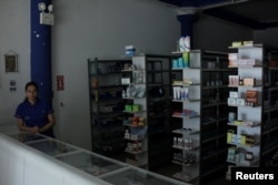 Una mujer espera clientes en una farmacia durante el apagón en San Cristobal, Venezuela.