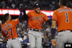 George Springer (c) de los Astros de Houston celebra junto a sus compañeros Jose Altuve (i) y Carlos Correa (d) luego de batear su cuarto jonrón consecutivo de la Serie Mundial 2017 en la segunda entrada del séptimo y definitivo juego