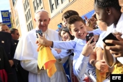 El Papa Francisco se toma selfies con los niños durante su visita a la escuela Nuestra Señora Reina de los Angeles. EFE