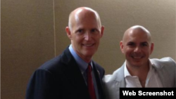 Pitbull(der.) posó junto al gobernador Rick Scott. 