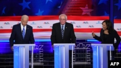 La senadora Kamala Harris en un intenso intercambio con el ex vicepresidente Joe Biden (a la izquierda). Entre ambos, el senador Bernie Sanders (Foto: AFP).