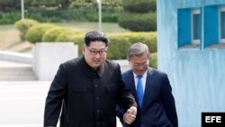 El dictador norcoreano, Kim Jong-un (d), y el presidente surcoreano, Moon Jae-in (i), se dan la mano mientras caminan por la Zona Desmilitarizada en Panmunjom (Corea del Sur), 27 de abril de 2018. 