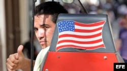 Un grupo de cubanos observa el paso del Air Force One, el avión presidencial estadounidense, sobre la localidad de Santiago de las Vegas.