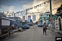 Una mujer cocina en la calle en un barrio de La Habana.