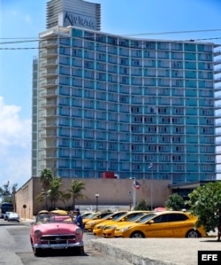 El conductor de un auto clásico espera turistas a las afueras de un hotel de La Habana.