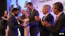 El cubano Julio Baptista Rodríguez (i), recibe de manos del rey Felipe VI el Premio Especial Iberoamericano de Periodismo Ambiental y Desarrollo Sostenible, que patrocina la Fundación Aquae, como autor del reportaje "Las aguas muertas del Havana Club", so