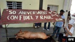 Un hombre cocina un cerdo hoy, en el portal de un edificio, en La Habana Vieja (Cuba)