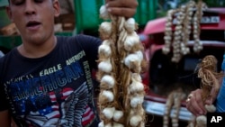 Un hombre vende una ristra de ajos en La Habana. AP Photo/Ramon Espinosa