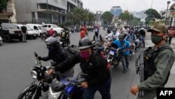 Guardias custodian una cola de gasolina en Venezuela.