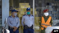 Policías cuidan las colas mientras los cubanos compran en dólares.