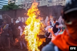 Orlando José Figueroa es alcanzado por las llamas durante una manifestación opositora en Caracas.