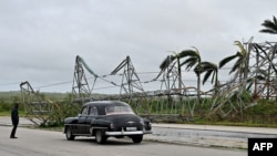 Un automóvil pasa junto a una torre eléctrica de alta tensión derribada durante el paso del huracán Rafael en la carretera que une Artemisa con La Habana, el 7 de noviembre de 2024.