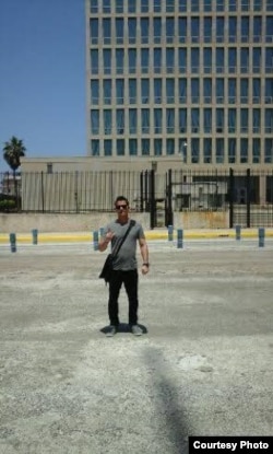 El activista del MCL, Michel Camacho, hace la señal de la libertad frente a la embajada de Estados Unidos en La Habana, 20 de julio 2015.