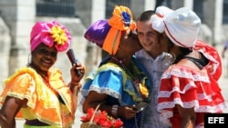 Un turista ruso se toma fotos con mujeres cubanas en la Plaza de Armas de La Habana. (Archivo)